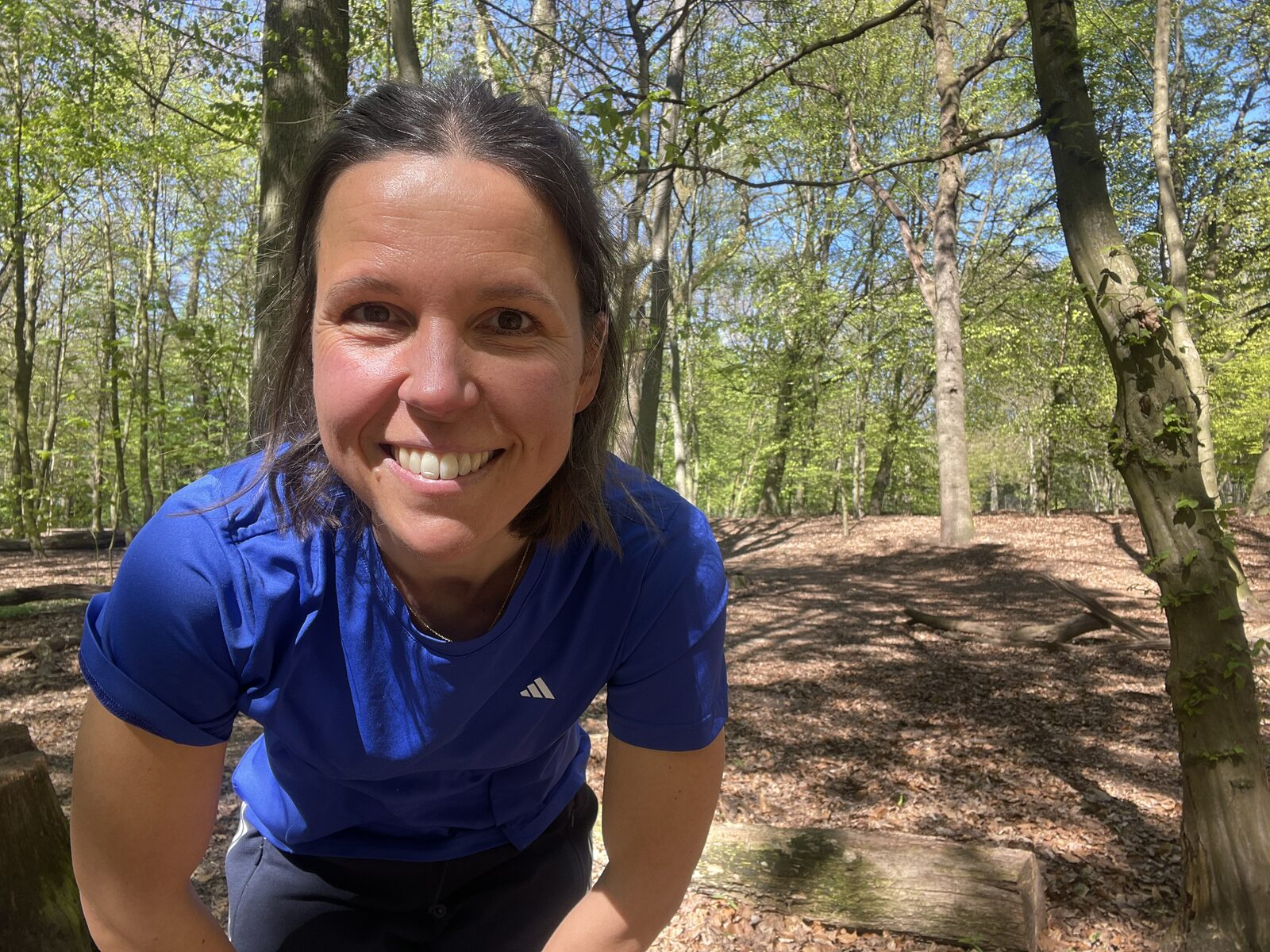 Sarah, Bewegungscoach aus Hamburg, lächelnd im Wald